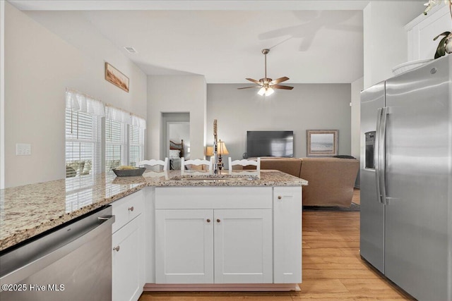 1673 White Starfish Ct, Calabash, NC 28467 - kitchen with appliances with stainless steel finishes, light wood finished floors, white cabinetry, open floor plan, and a ceiling fan