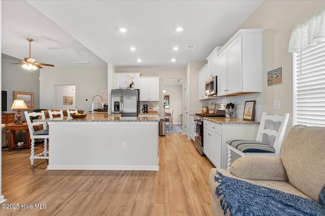 1673 White Starfish Ct, Calabash, NC 28467 - kitchen with appliances with stainless steel finishes, light wood-type flooring, white cabinetry, and recessed lighting