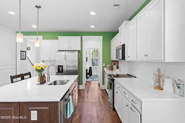 9154 Village Lake Dr SW, Calabash, NC 28467 - kitchen featuring appliances with stainless steel finishes, decorative backsplash, dark wood-style floors, recessed lighting, and white cabinetry