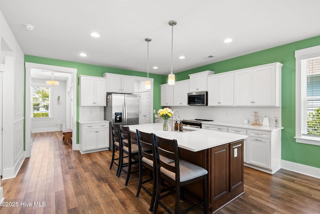 9154 Village Lake Dr SW, Calabash, NC 28467 - kitchen with appliances with stainless steel finishes, tasteful backsplash, a breakfast bar area, dark wood finished floors, and recessed lighting