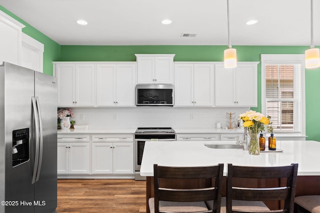 9154 Village Lake Dr SW, Calabash, NC 28467 - kitchen with appliances with stainless steel finishes, a kitchen breakfast bar, light countertops, tasteful backsplash, and recessed lighting