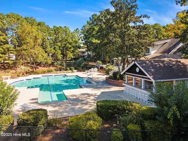 9154 Village Lake Dr SW, Calabash, NC 28467 - community pool with a patio and view of wooded area