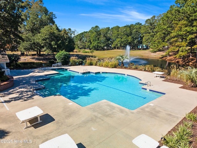 9154 Village Lake Dr SW, Calabash, NC 28467 - community pool featuring a patio, a water view, and view of scattered trees
