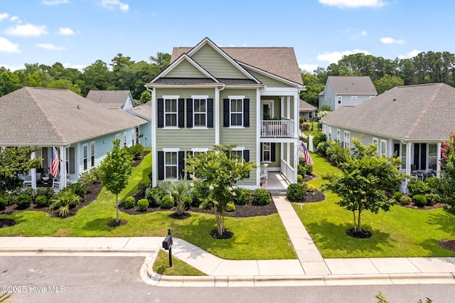 9154 Village Lake Dr SW, Calabash, NC 28467 - neoclassical / greek revival house with a balcony, a front lawn, and a shingled roof