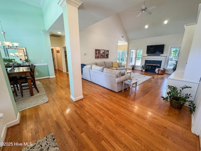 4725 Wedgefield Dr, Wilmington, NC 28409 - living area with high vaulted ceiling, light wood finished floors, ceiling fan, a glass covered fireplace, and ornate columns