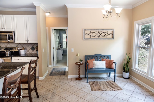 4725 Wedgefield Dr, Wilmington, NC 28409 - kitchen with stainless steel appliances, a chandelier, healthy amount of natural light, ornamental molding, and white cabinets