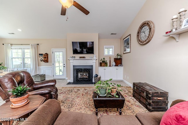 276 Widgeon Way, Lillington, NC 27546 - carpeted living room featuring ceiling fan, a fireplace with flush hearth, plenty of natural light, and a wainscoted wall