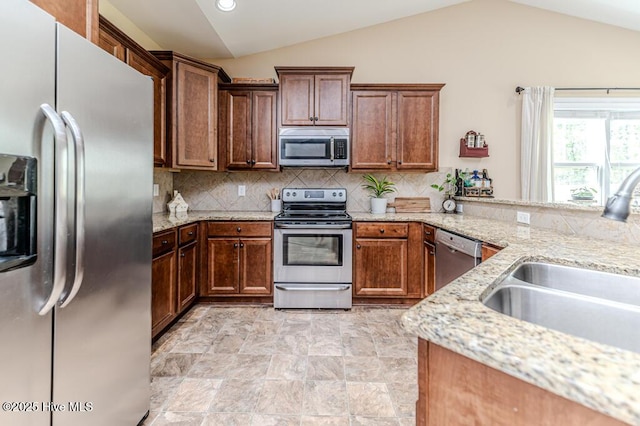276 Widgeon Way, Lillington, NC 27546 - kitchen with appliances with stainless steel finishes, vaulted ceiling, decorative backsplash, light stone countertops, and recessed lighting