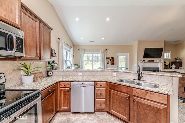 276 Widgeon Way, Lillington, NC 27546 - kitchen featuring stainless steel appliances, light stone counters, brown cabinetry, tasteful backsplash, and recessed lighting