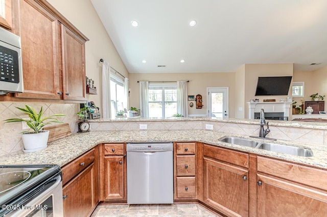 276 Widgeon Way, Lillington, NC 27546 - kitchen with stainless steel appliances, light stone counters, tasteful backsplash, brown cabinets, and recessed lighting