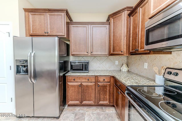276 Widgeon Way, Lillington, NC 27546 - kitchen with appliances with stainless steel finishes, light stone counters, decorative backsplash, and brown cabinetry