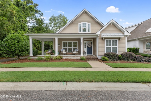 8203 Brays Dr, Wilmington, NC 28411 - view of front of property with a porch, a front lawn, a metal roof, and a standing seam roof