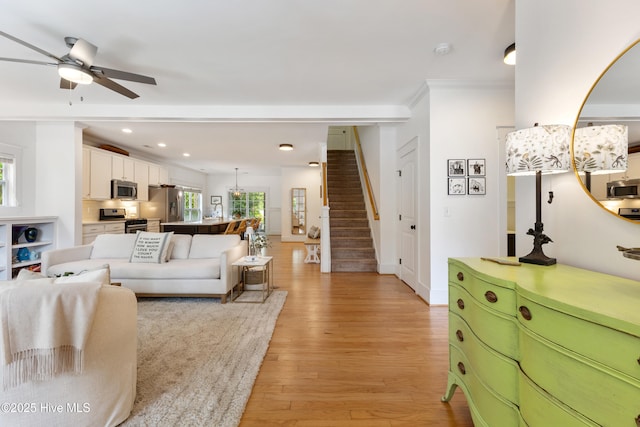 8203 Brays Dr, Wilmington, NC 28411 - living room featuring stairway, light wood-style floors, ceiling fan, recessed lighting, and crown molding