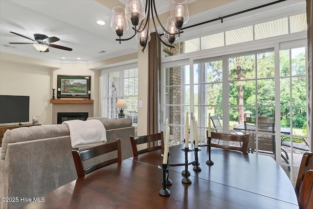 240 Cochrane Castle Cir Unit F, Pinehurst, NC 28374 - dining room featuring ornamental molding, a glass covered fireplace, a ceiling fan, a chandelier, and recessed lighting