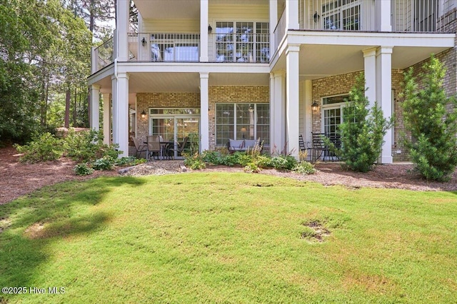 240 Cochrane Castle Cir Unit F, Pinehurst, NC 28374 - back of house featuring a balcony, brick siding, and a yard
