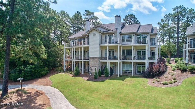 240 Cochrane Castle Cir Unit F, Pinehurst, NC 28374 - back of property with a chimney, a balcony, and a lawn