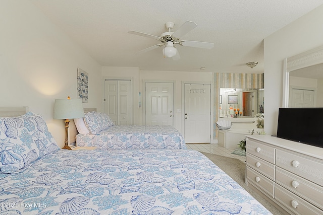 330 S Middleton Dr NW Unit 1009, Calabash, NC 28467 - bedroom featuring multiple closets, ensuite bathroom, a ceiling fan, and light tile patterned floors