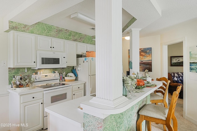 330 S Middleton Dr NW Unit 1009, Calabash, NC 28467 - kitchen with white appliances, a breakfast bar, white cabinets, a textured ceiling, and light countertops