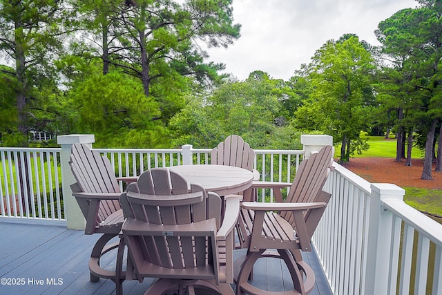 330 S Middleton Dr NW Unit 1009, Calabash, NC 28467 - deck featuring outdoor dining area and view of wooded area