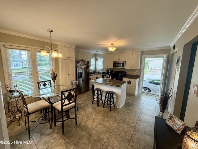 2834 Lancaster Rd NW, Wilson, NC 27896 - kitchen with appliances with stainless steel finishes, ornamental molding, a center island, dark countertops, and white cabinets