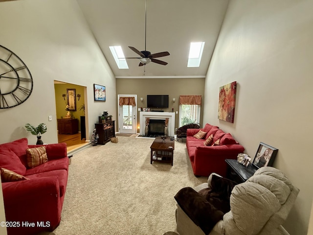 2834 Lancaster Rd NW, Wilson, NC 27896 - living area featuring a skylight, high vaulted ceiling, carpet floors, ceiling fan, and a fireplace with flush hearth