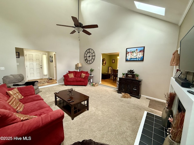 2834 Lancaster Rd NW, Wilson, NC 27896 - carpeted living room with high vaulted ceiling, a skylight, a ceiling fan, and a fireplace with flush hearth