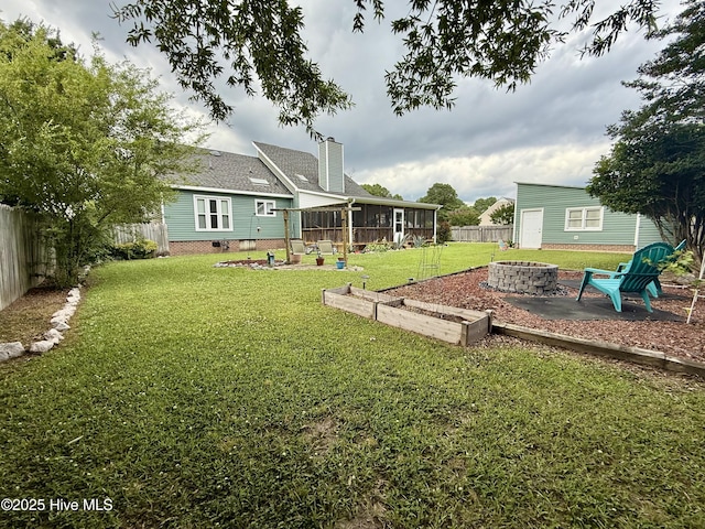 2834 Lancaster Rd NW, Wilson, NC 27896 - fenced backyard featuring a fire pit and a sunroom