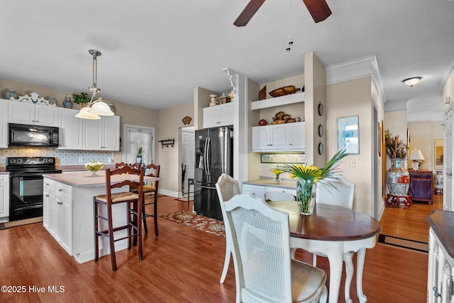 6122 Timber Creek Ln, Wilmington, NC 28411 - dining area featuring wood finished floors, a ceiling fan, and crown molding