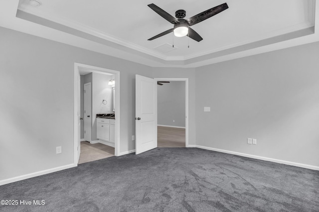6468 Merceron St SW, Ocean Isle Beach, NC 28469 - unfurnished bedroom featuring a raised ceiling, carpet floors, ornamental molding, ensuite bathroom, and ceiling fan