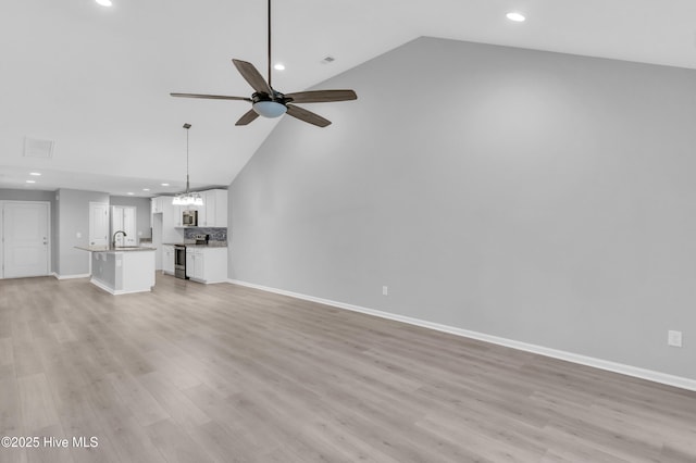 6468 Merceron St SW, Ocean Isle Beach, NC 28469 - unfurnished living room with recessed lighting, a ceiling fan, high vaulted ceiling, and light wood finished floors