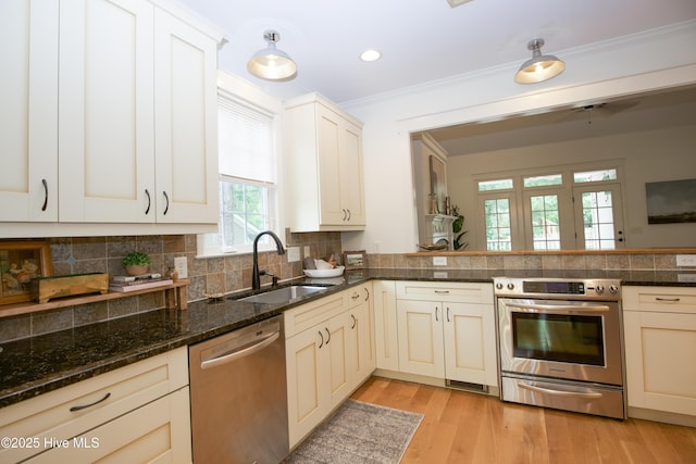 2 Tyler Way, Pinehurst, NC 28374 - kitchen featuring appliances with stainless steel finishes, decorative backsplash, crown molding, light wood-type flooring, and dark stone counters
