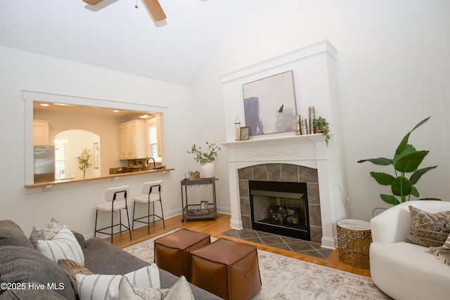 2 Tyler Way, Pinehurst, NC 28374 - living room with lofted ceiling, ceiling fan, a tile fireplace, wood finished floors, and arched walkways