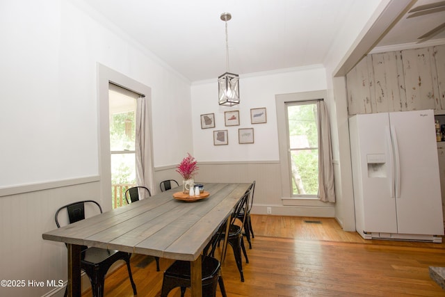 615 E Main St, Aberdeen, NC 28315 - dining area with light wood-style flooring, a wainscoted wall, crown molding, and a chandelier