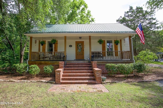 615 E Main St, Aberdeen, NC 28315 - bungalow-style house with covered porch, a metal roof, and a front lawn