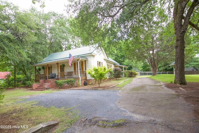 615 E Main St, Aberdeen, NC 28315 - view of front of property with covered porch, driveway, a metal roof, and crawl space