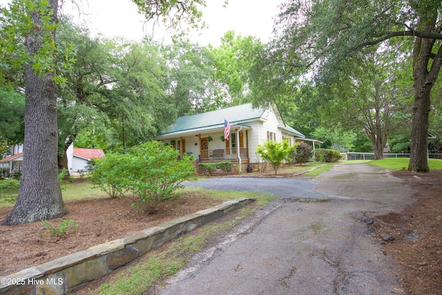 615 E Main St, Aberdeen, NC 28315 - view of front of house featuring covered porch, asphalt driveway, and a metal roof