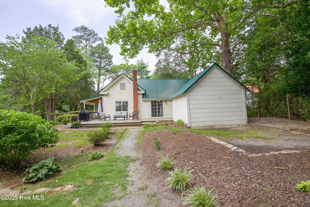 615 E Main St, Aberdeen, NC 28315 - rear view of house featuring a deck, a chimney, and a metal roof
