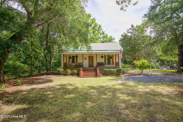 615 E Main St, Aberdeen, NC 28315 - view of front facade featuring covered porch, a metal roof, and a front lawn