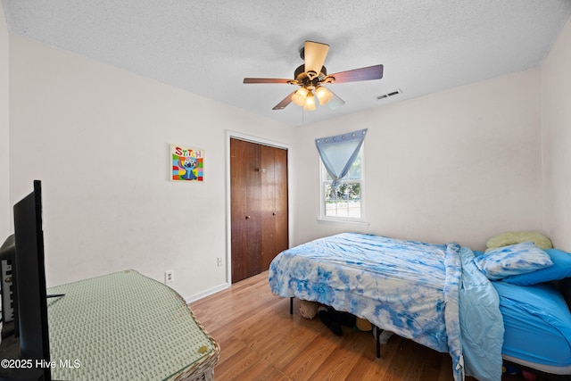608 Calabash Dr, Hubert, NC 28539 - bedroom featuring wood finished floors, a textured ceiling, a ceiling fan, and a closet
