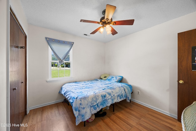 608 Calabash Dr, Hubert, NC 28539 - bedroom featuring wood finished floors, a closet, a textured ceiling, and a ceiling fan