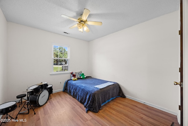608 Calabash Dr, Hubert, NC 28539 - bedroom featuring wood finished floors, a textured ceiling, and a ceiling fan