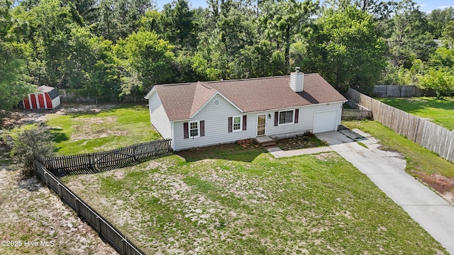 608 Calabash Dr, Hubert, NC 28539 - view of front facade with concrete driveway, a garage, a chimney, a fenced backyard, and roof with shingles