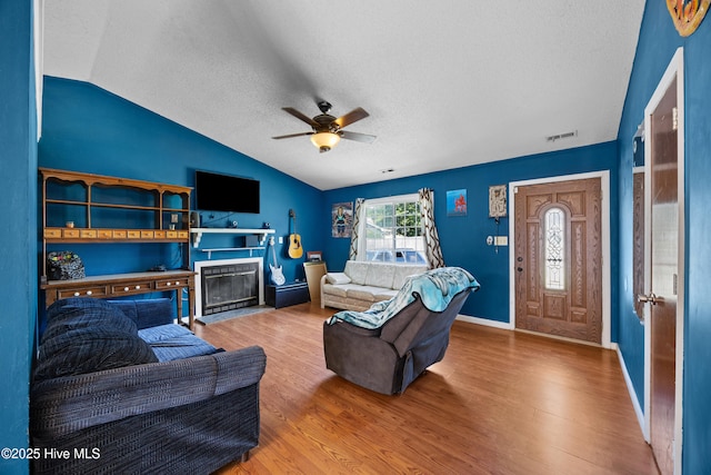 608 Calabash Dr, Hubert, NC 28539 - living room featuring lofted ceiling, a textured ceiling, ceiling fan, wood finished floors, and a fireplace with flush hearth