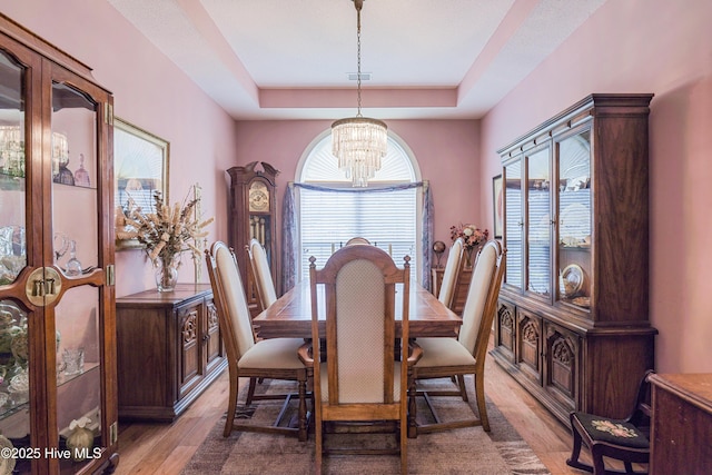 1045 Edenton Dr NW, Calabash, NC 28467 - dining area with a chandelier, a raised ceiling, and light wood-type flooring