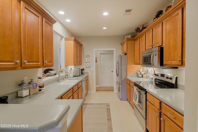 1045 Edenton Dr NW, Calabash, NC 28467 - kitchen with stainless steel appliances, recessed lighting, light countertops, light tile patterned flooring, and brown cabinets