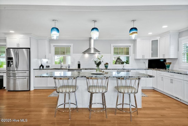 311 Lennox Pl, Wilmington, NC 28412 - kitchen with stainless steel fridge, wall chimney range hood, white cabinetry, tasteful backsplash, and ornamental molding