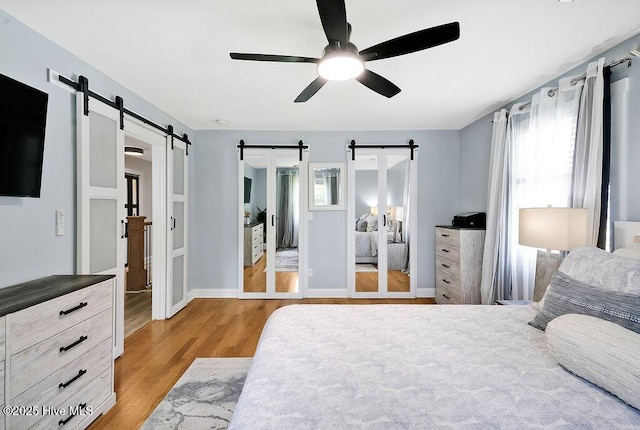 311 Lennox Pl, Wilmington, NC 28412 - bedroom with a barn door, light wood-style flooring, multiple windows, and ceiling fan