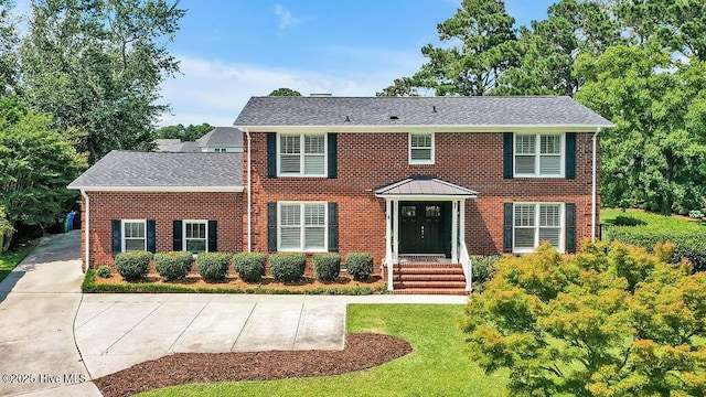 311 Lennox Pl, Wilmington, NC 28412 - colonial home with brick siding, roof with shingles, and a front lawn