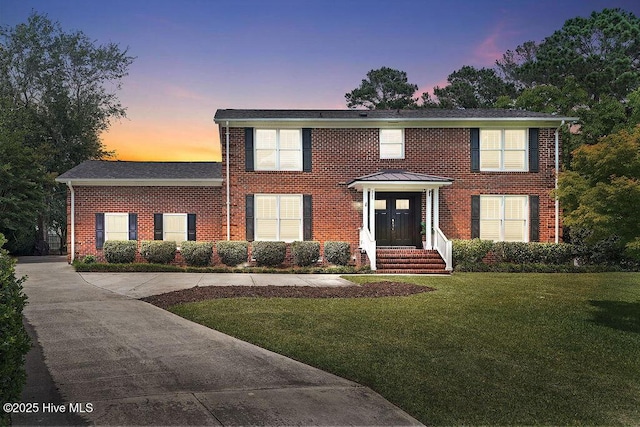 311 Lennox Pl, Wilmington, NC 28412 - colonial-style house with brick siding and a front lawn