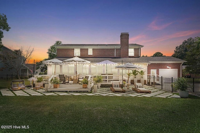 311 Lennox Pl, Wilmington, NC 28412 - back of property at dusk with a chimney, a patio, and brick siding